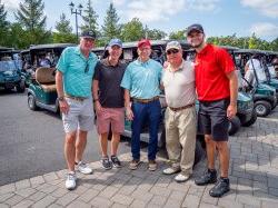 Group poses in front of golf carts