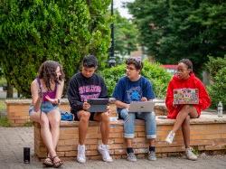 four students sitting and chatting