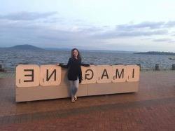 Student in front of sign reading Imagine